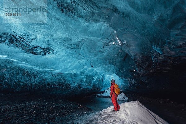 Mann schaut in die Eishöhle  Vatnajokull Gletscher  Vatnajokull Nationalpark  Island