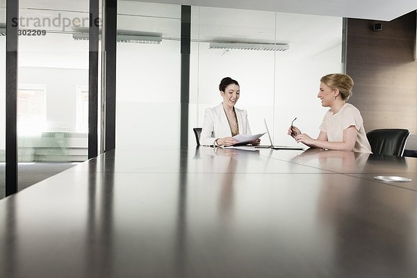 Zwei junge Geschäftsfrauen treffen sich im Sitzungssaal