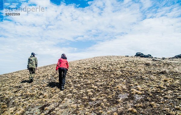 Rückansicht zweier junger Frauen beim Bergwandern