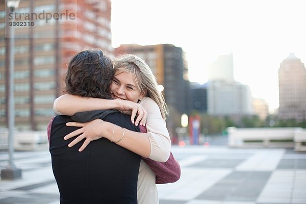 Mid Erwachsene Mann umarmende Freundin auf dem Dach Parkplatz
