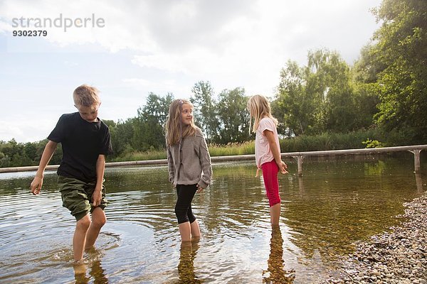 Bruder und zwei Schwestern beim Paddeln im See