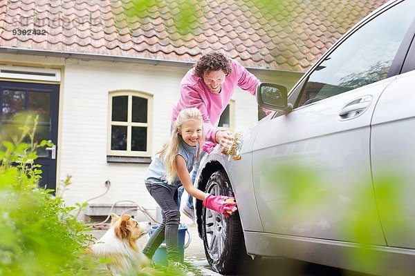 Mädchen hilft Vater beim Autowaschen