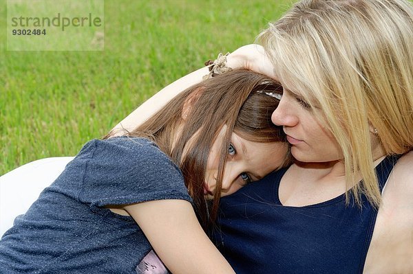 Nahaufnahme von Mädchen und Mutter beim Umarmen im Park