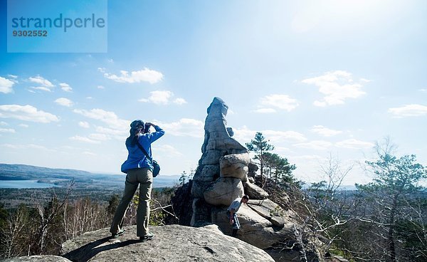 Zwei Wanderer auf einer Felsformation beim Fotografieren