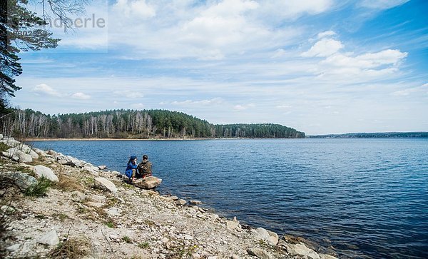 Zwei weibliche Wanderfreunde bei einer Pause am Seeufer