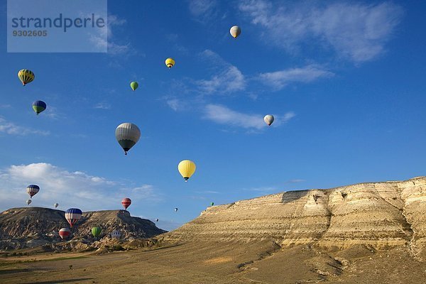 Große Gruppe von Heißluftballons  die über Berge  Kappadokien  Anatolien  Türkei in die Ferne schweben.