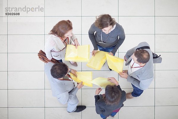 Overhead-Ansicht von Geschäftsfrauen und Männern mit Papierkram im Atrium des Konferenzzentrums