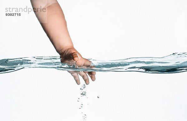 Blick auf die Oberfläche von Kleinkindern  die mit der Hand ins klare Wasser greifen