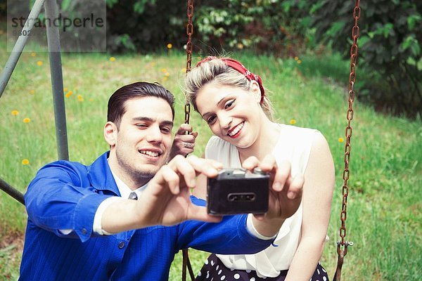 Junges Vintage-Paar mit Selfie-Kamera im Garten
