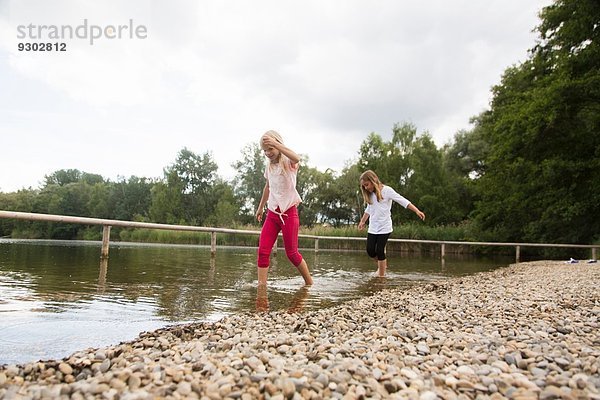 Zwei Mädchen paddeln im ländlichen See