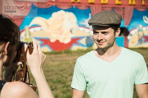 Junges Paar beim Fotografieren mit Spiegelreflexkamera auf der Kirmes