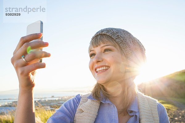 Junge Frau nimmt Selfie mit Smartphone