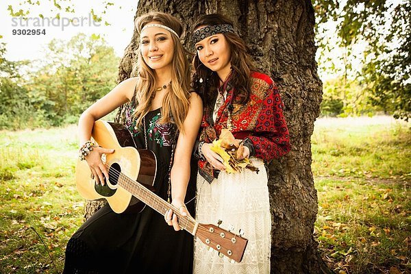 Hippy Girls bei Baum mit Gitarre
