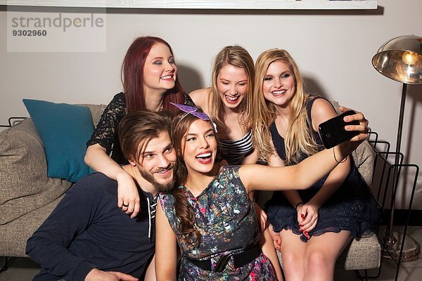 Freunde nehmen Selfie auf dem Sofa.