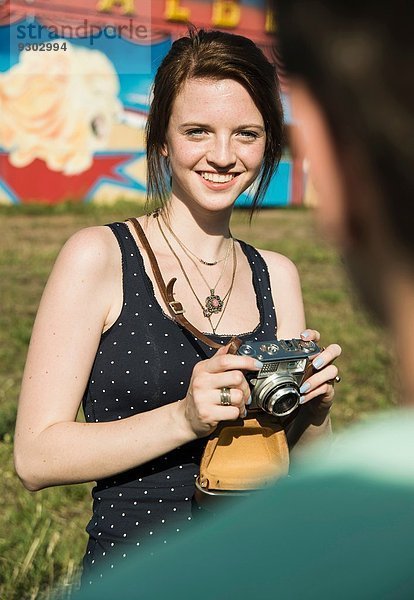 Junges Paar fotografiert auf der Kirmes mit Spiegelreflexkamera