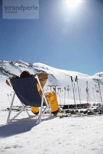 Rückansicht eines erwachsenen Skifahrers auf einem Liegestuhl  Österreich