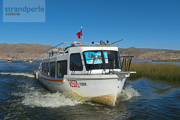 Ausflugsboot auf dem Titicaca-See  hinten die Stadt  Puno  Peru