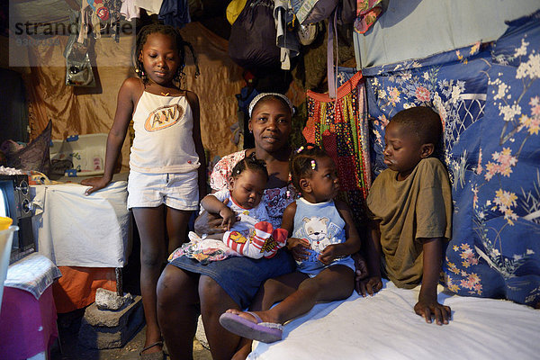 Frau mit vier Kindern in einer ärmlichen Baracke  Lager für Erdbebenflüchtlinge Camp Icare  Fort National  Port-au-Prince  Haiti