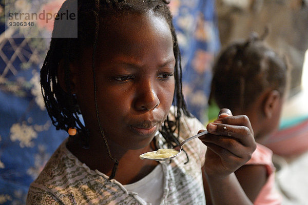 Mädchen  9 Jahre  isst Suppe in einer ärmlichen Baracke  Lager für Erdbebenflüchtlinge Camp Icare  Fort National  Port-au-Prince  Haiti