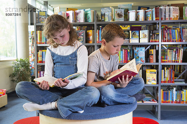 Zwei Kinder beim Lesen in einer öffentlichen Bibliothek  Stadtbibliothek  Coswig  Sachsen  Deutschland