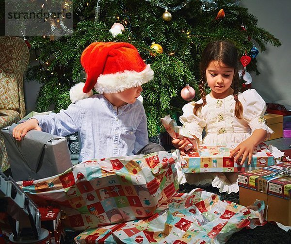 Kinder eröffnen Weihnachtsgeschenke