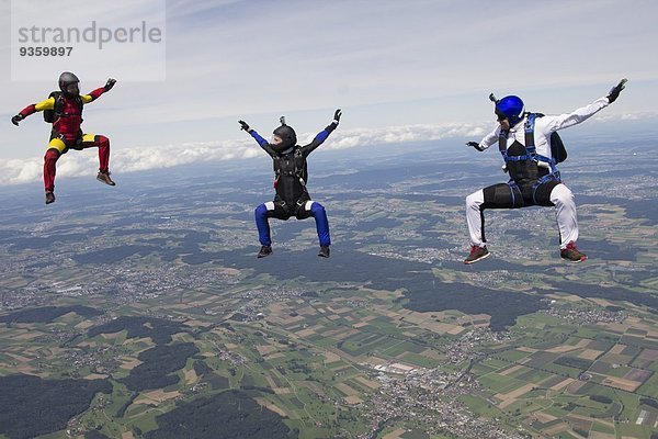 Team von drei Fallschirmspringern in Sitzposition über Buttwil  Luzern  Schweiz