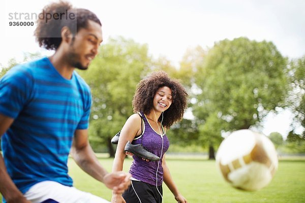 Junges Fußballpärchen spielt keepy uppy im Park