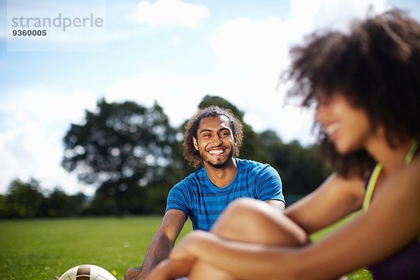 Junges Fußballpärchen macht Pause im Park