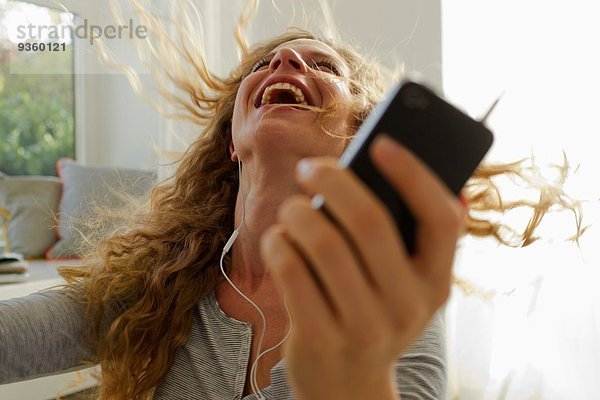 Frau tanzt zu Musik auf dem Smartphone