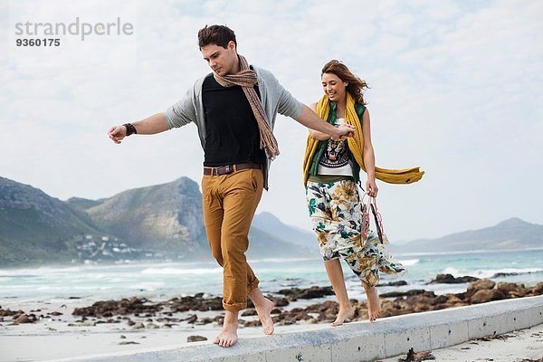 Junges Paar  das am Strand entlanggeht  Kapstadt  Westkap  Südafrika