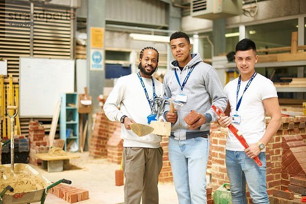 Porträt von drei männlichen Studenten in der Maurerwerkstatt