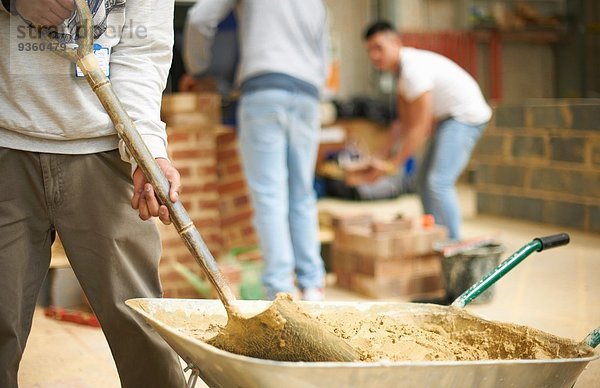 Schnittaufnahme von drei männlichen Studenten in der Maurerwerkstatt