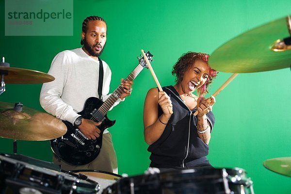 Schüler spielen Gitarre und Schlagzeug im College-Musikzimmer