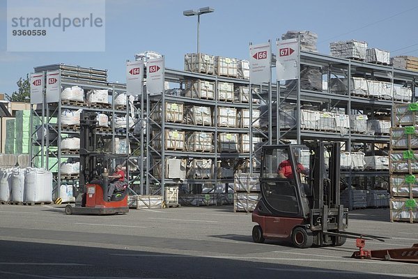 Zwei männliche Lagerarbeiter bewegen Lagerbestände in Gabelstaplern