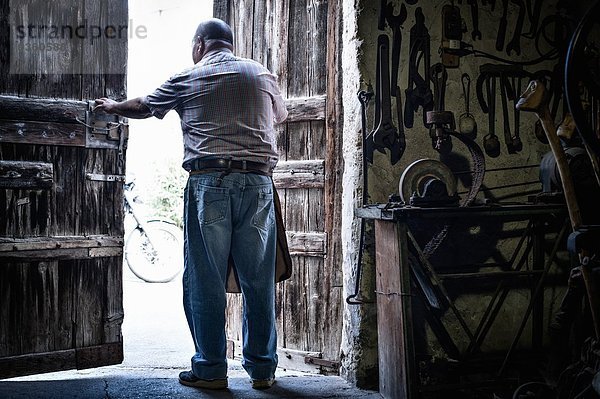 Rückansicht des älteren Schmiedes in den Türen der traditionellen Scheune  Cagliari  Sardinien  Italien