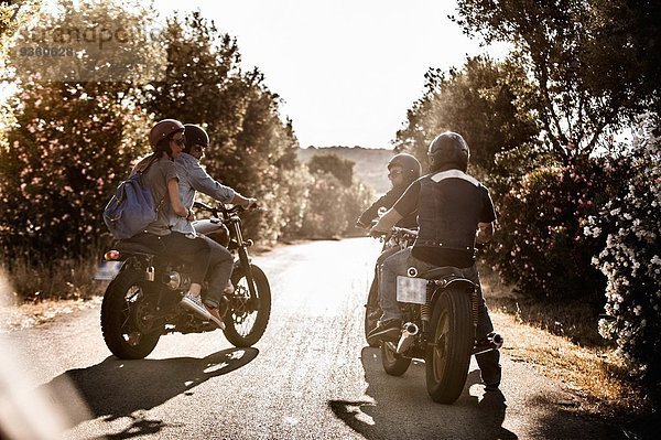 Rückansicht von vier Freunden auf Motorrädern beim Plaudern auf der Landstraße  Cagliari  Sardinien  Italien