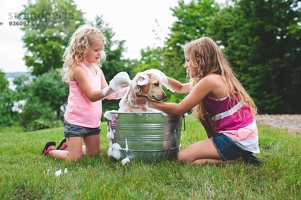 Zwei Schwestern baden Haustier Labrador Retriever Welpe