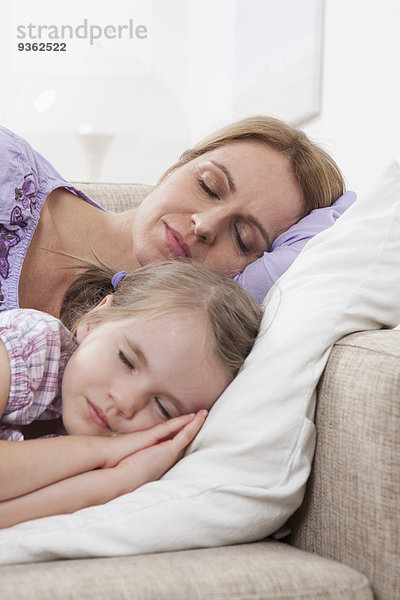 Deutschland  München  Mutter und Tochter (4-5) schlafen auf Sofa