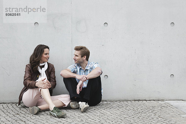 Deutschland  Berlin  Mann und Frau sitzen an der Wand