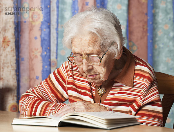 Porträt einer älteren Frau beim Lesen eines Buches