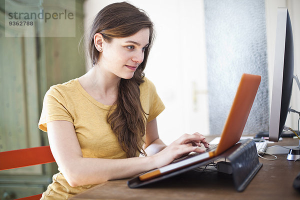 Junge Frau mit ihrem Laptop zu Hause
