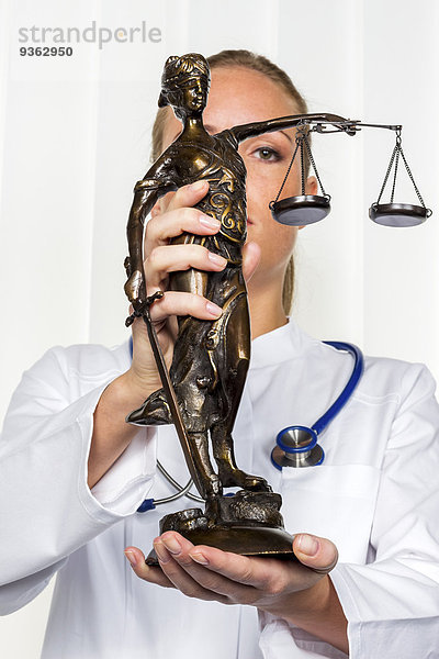 Ärztin mit Lady Justice Figur