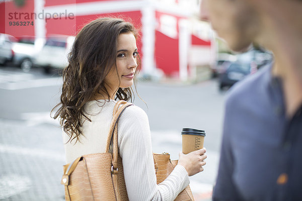 Porträt einer Frau mit Kaffee zum Mitnehmen