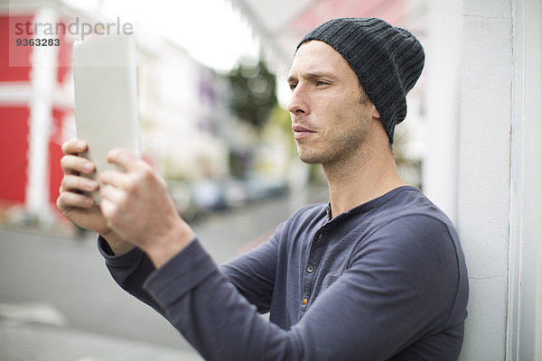Porträt eines jungen Mannes  der einen Selfie mit seinem digitalen Tablett nimmt.