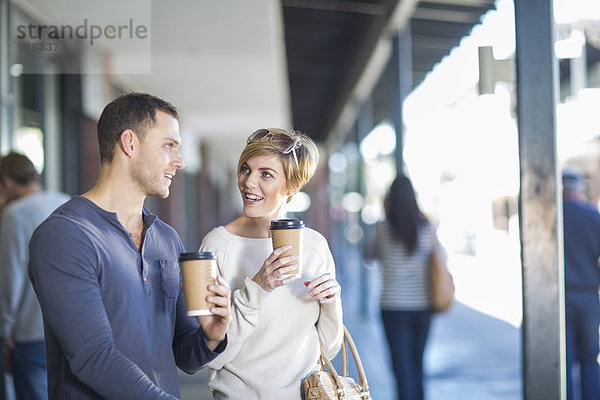 Lächelndes Paar mit Kaffee zum Mitnehmen