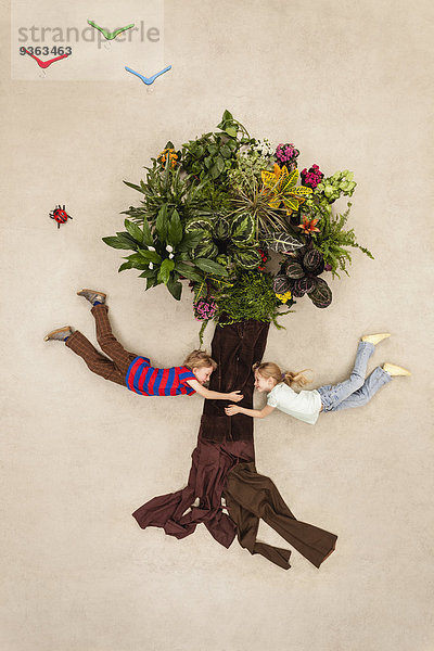 Junge und Mädchen halten sich an einem Baum fest