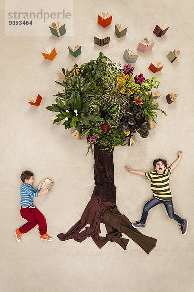 Kinder beobachten Bücher  die aus dem Baum fliegen