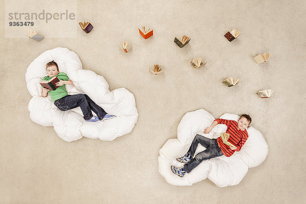 Jungen auf Wolken liegend  lesend