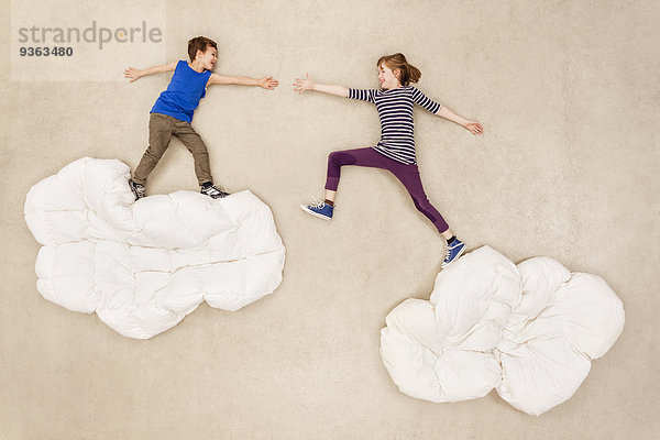 Kinder springen über Wolken
