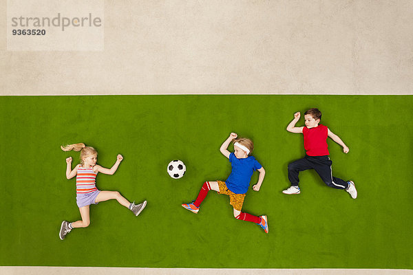 Kinder spielen Fußball im Park